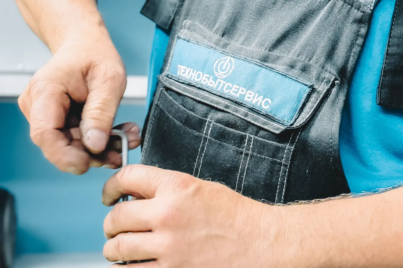 A plumber working on a pipe connection with a wrench.