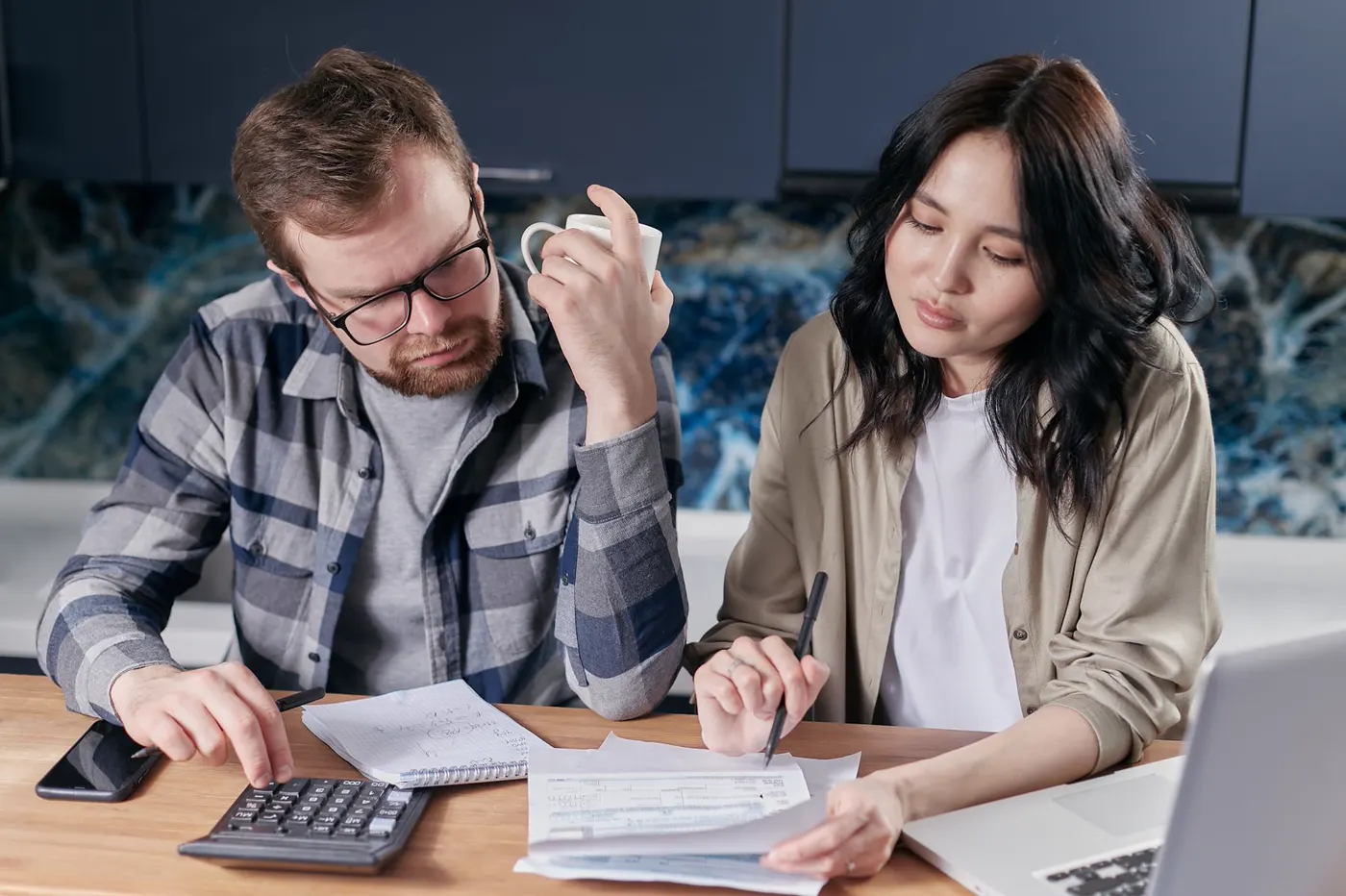 A household reviewing bills and a budget at a kitchen table.